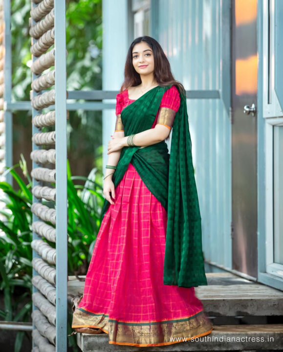 Athmika Sumithran in red and bottle green half saree